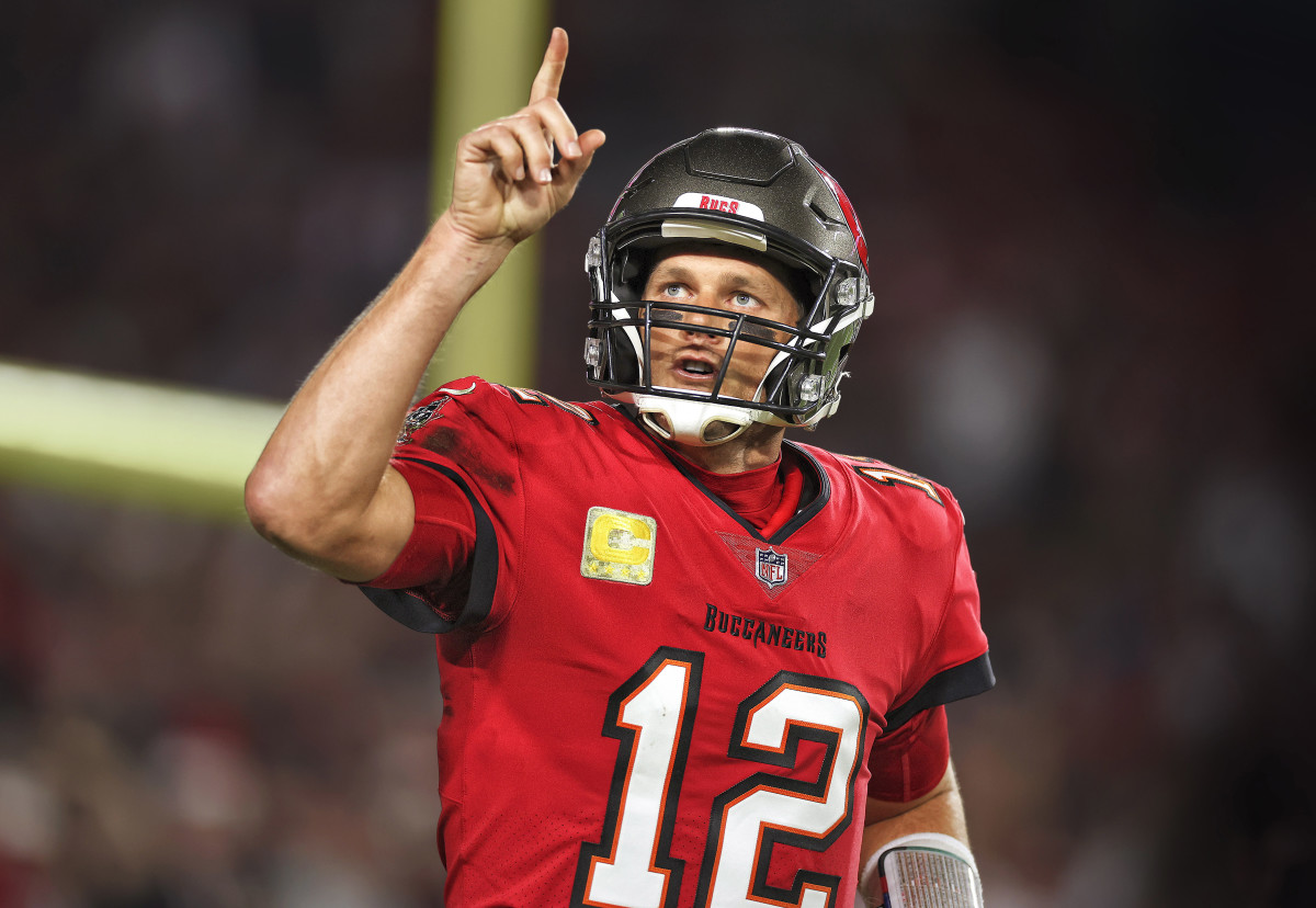 Tom Brady points to the sky as he runs on the field for a Bucs game